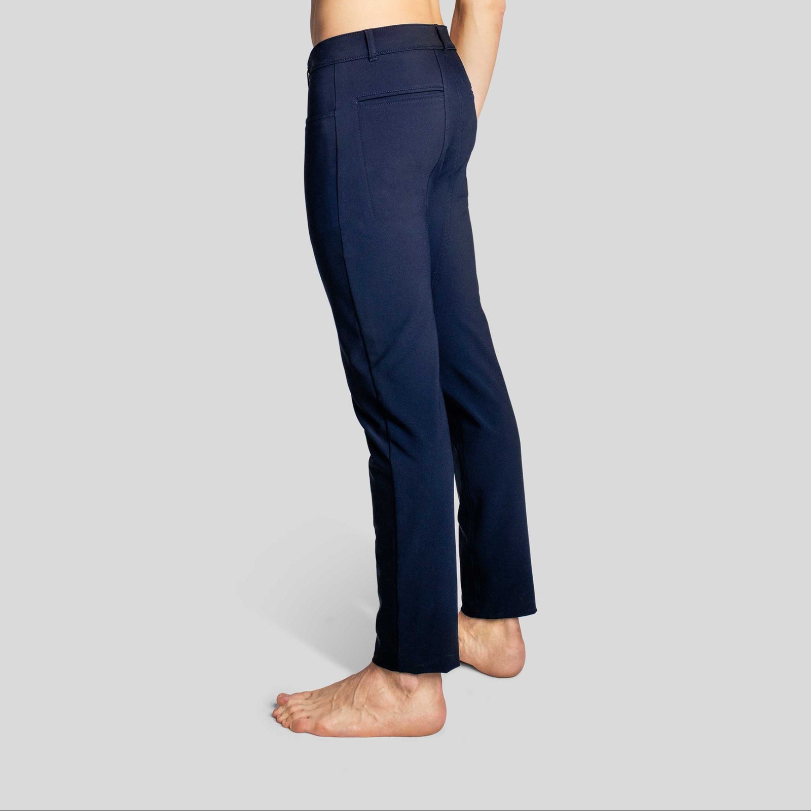 Side-back view of a man in The Pants by åäö in Blur Black, highlighting their timeless design and tailored fit.