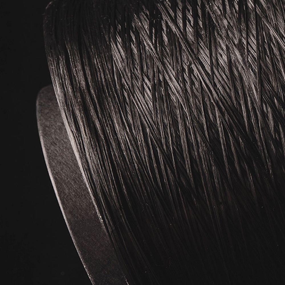 Close-up of Dyneema thread on a spool, showcasing its fine texture and reflection in the light.