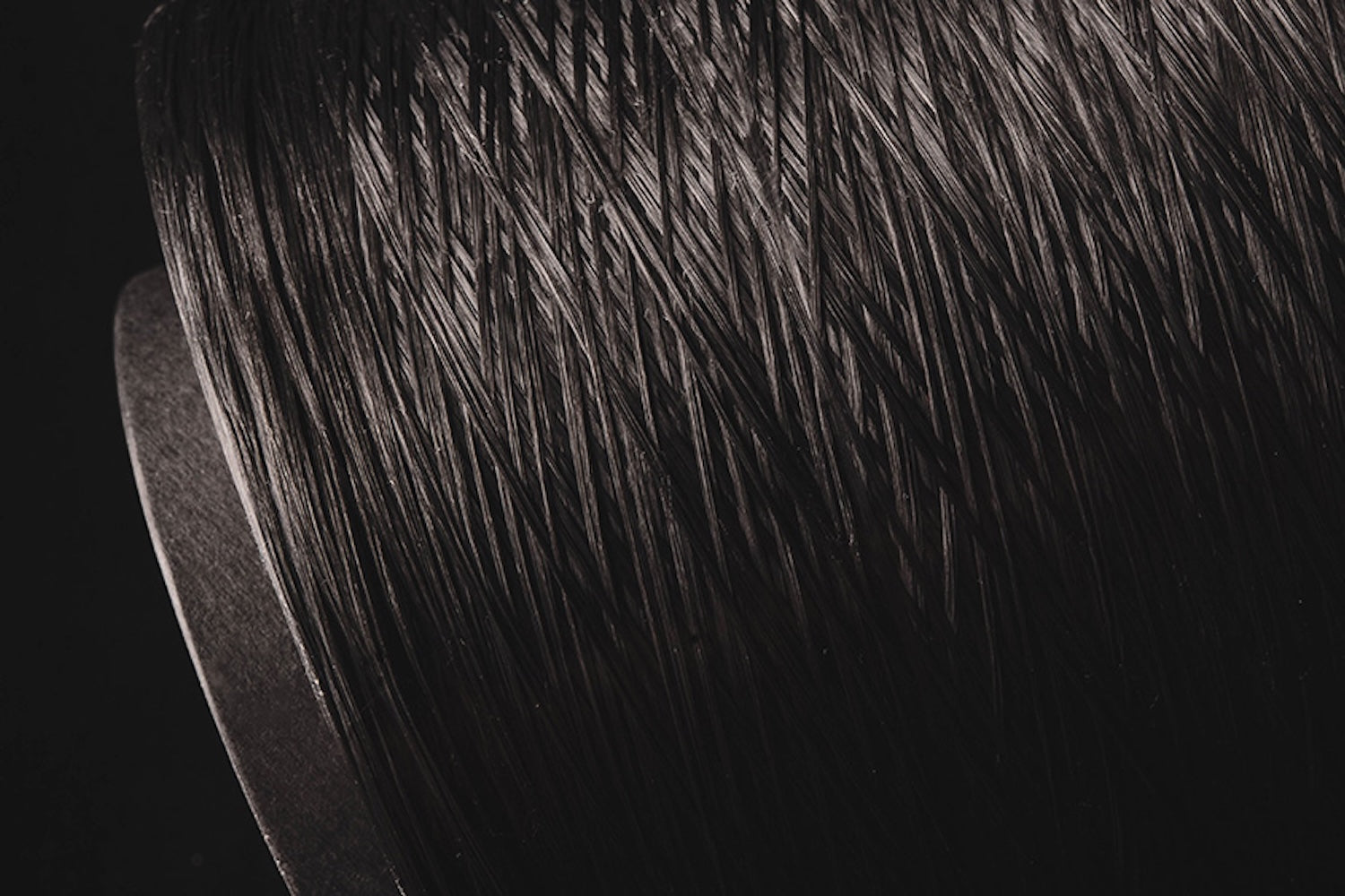 Close-up of Dyneema thread on a spool, showcasing its fine texture and reflection in the light.