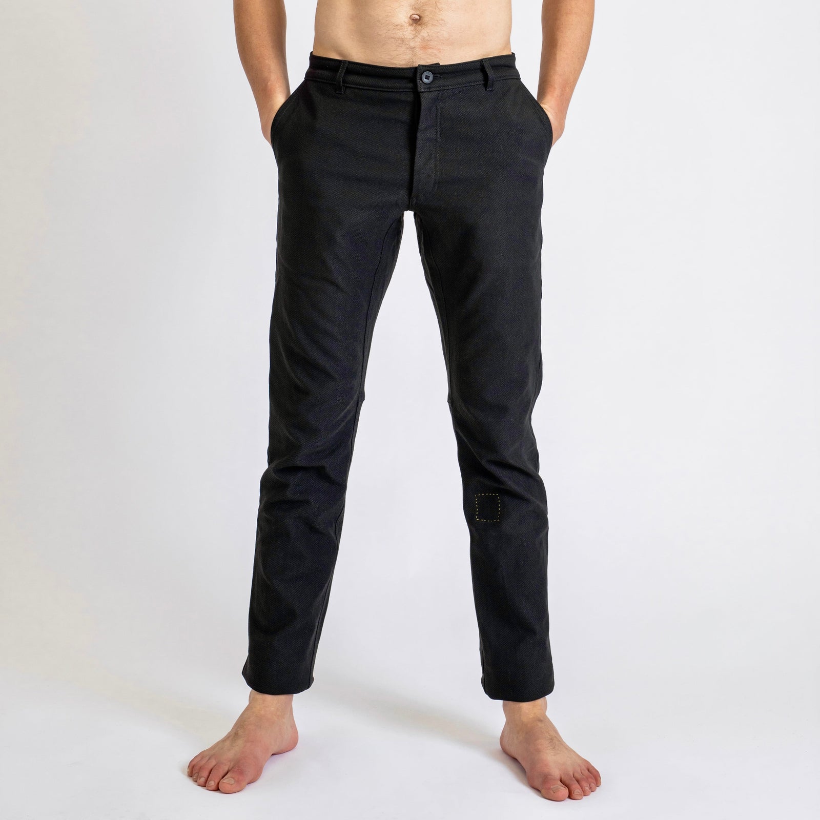 Front view of a man wearing åäö’s Forever Pants, highlighting the crafted texture of Dyneema fabric and the perfected fit. 