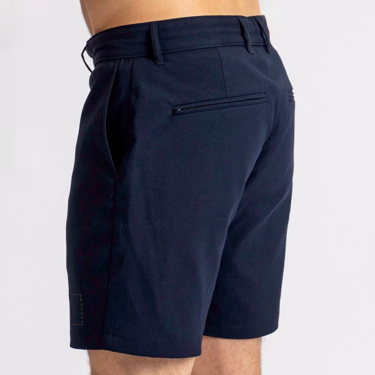 Side-rear view of a man in The Shorts by åäö in Deep Blue, highlighting their perfected fit and timeless design.