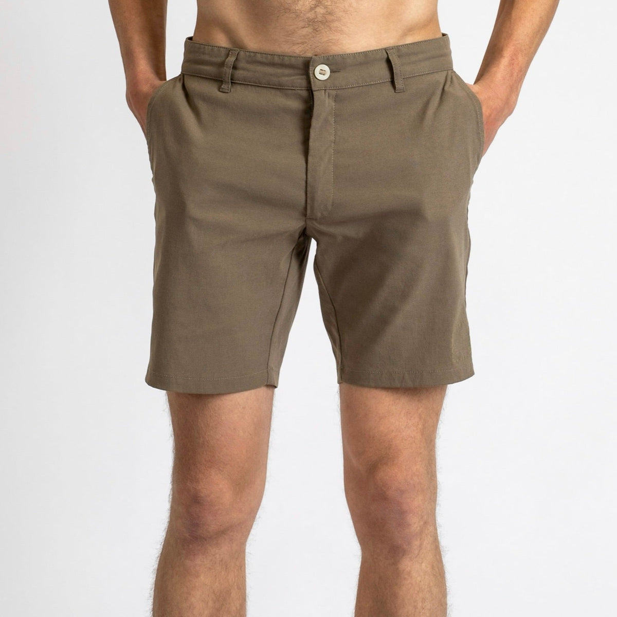 Front view of a man in åäö’s Shorts in Dusty Desert, hands in pockets, showcasing their timeless design and perfected fit.