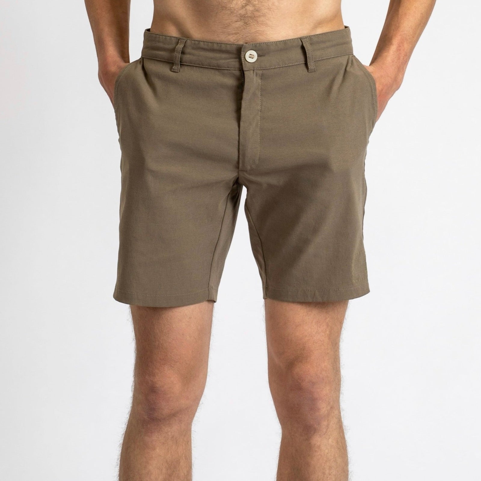 Front view of a man in åäö’s Shorts in Dusty Desert, hands in pockets, showcasing their timeless design and perfected fit.