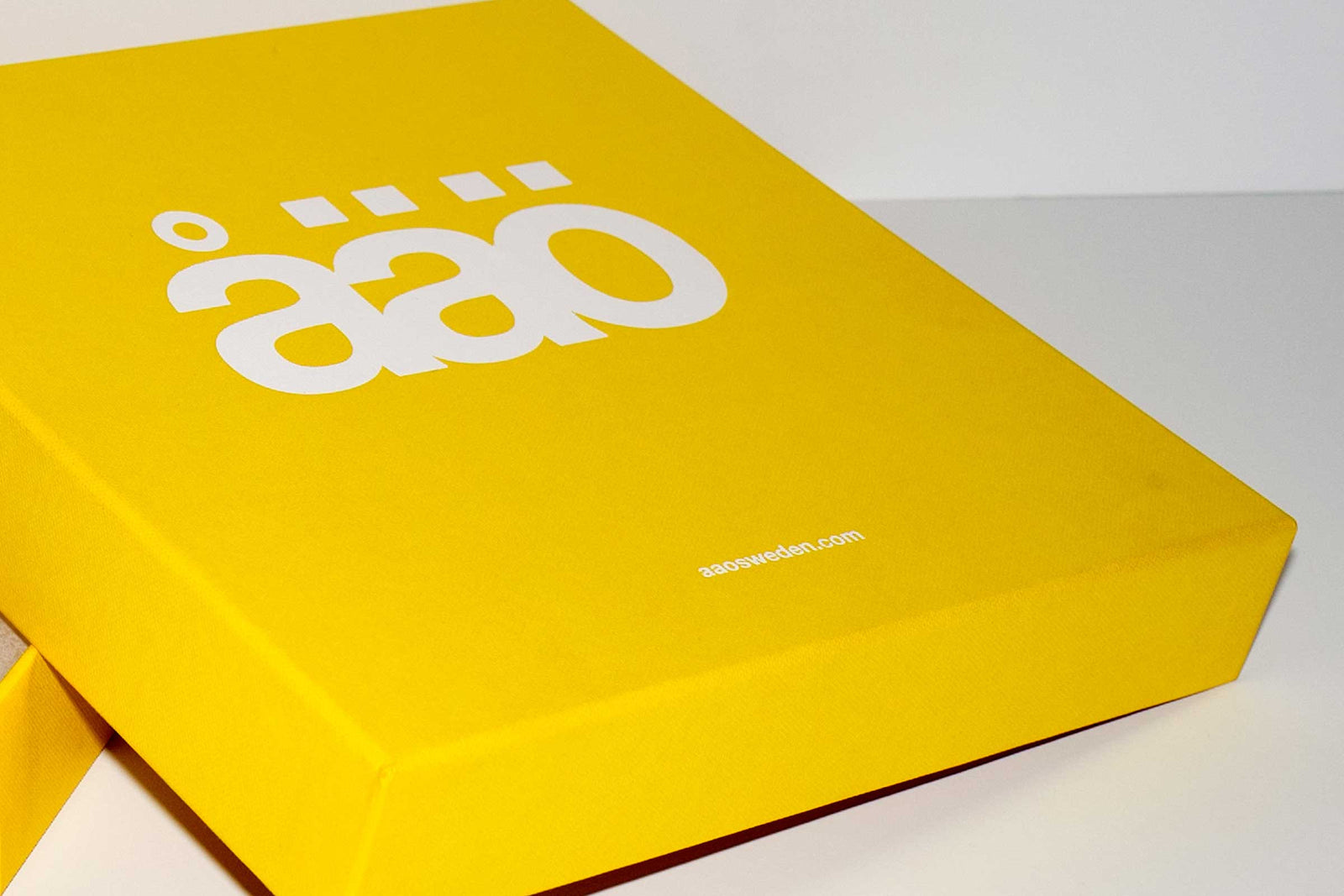 A vibrant yellow åäö product box with the logo printed on it.