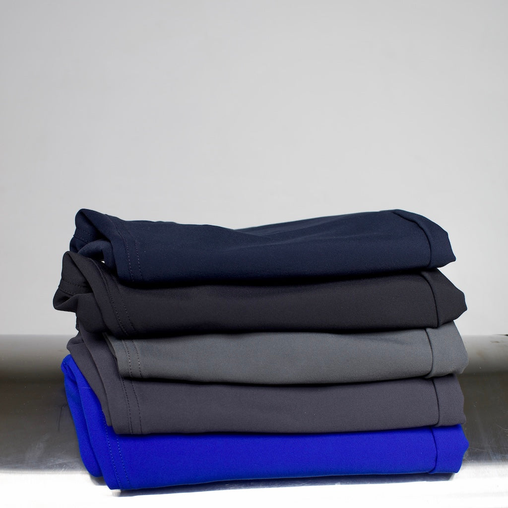 Flatlay of The Pants by åäö in all colors, neatly folded and stacked, highlighting the rich hues and premium fabric
