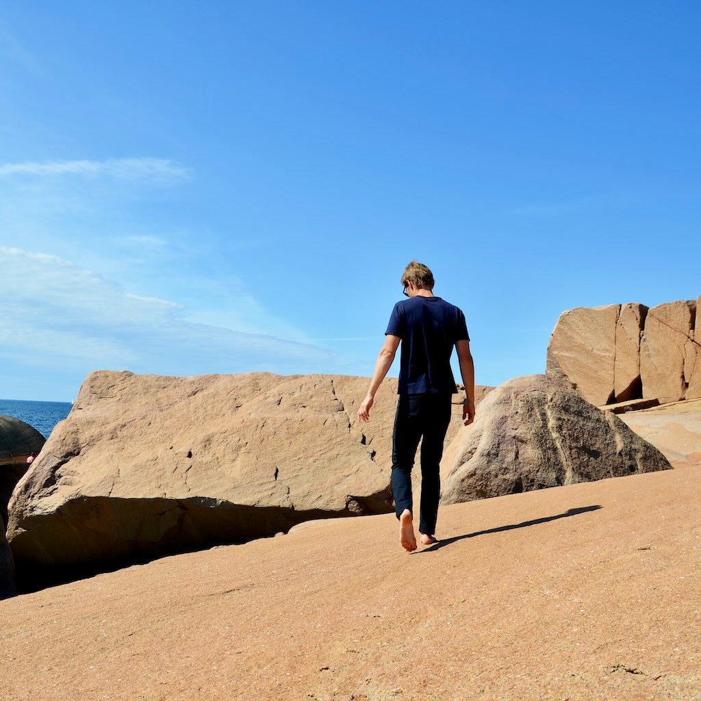 A man walking on kalksten, wearing The Pants by åäö, blending comfort and style.