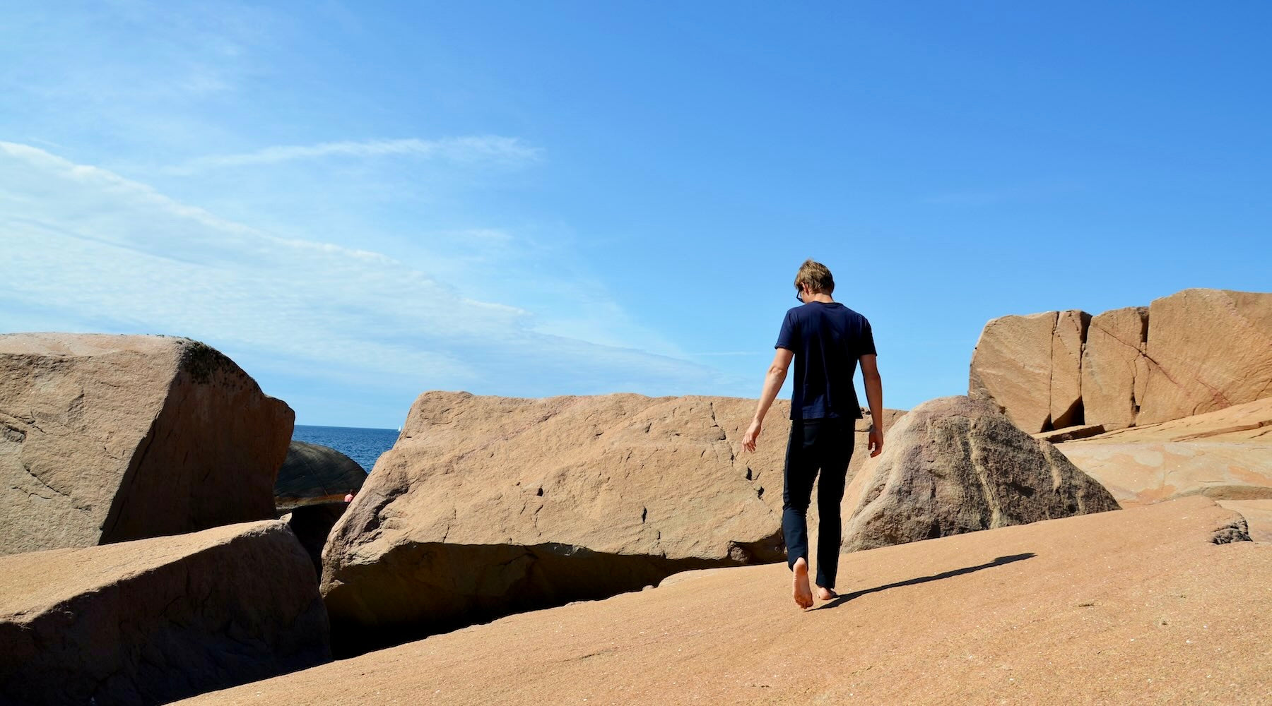 A man walking on kalksten, wearing The Pants by åäö, blending comfort and style.