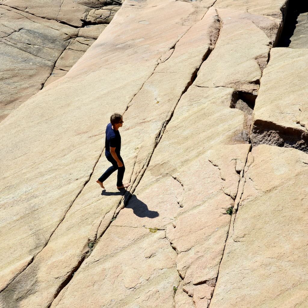 A man walking on kalksten, wearing The Pants by åäö, blending comfort and style.