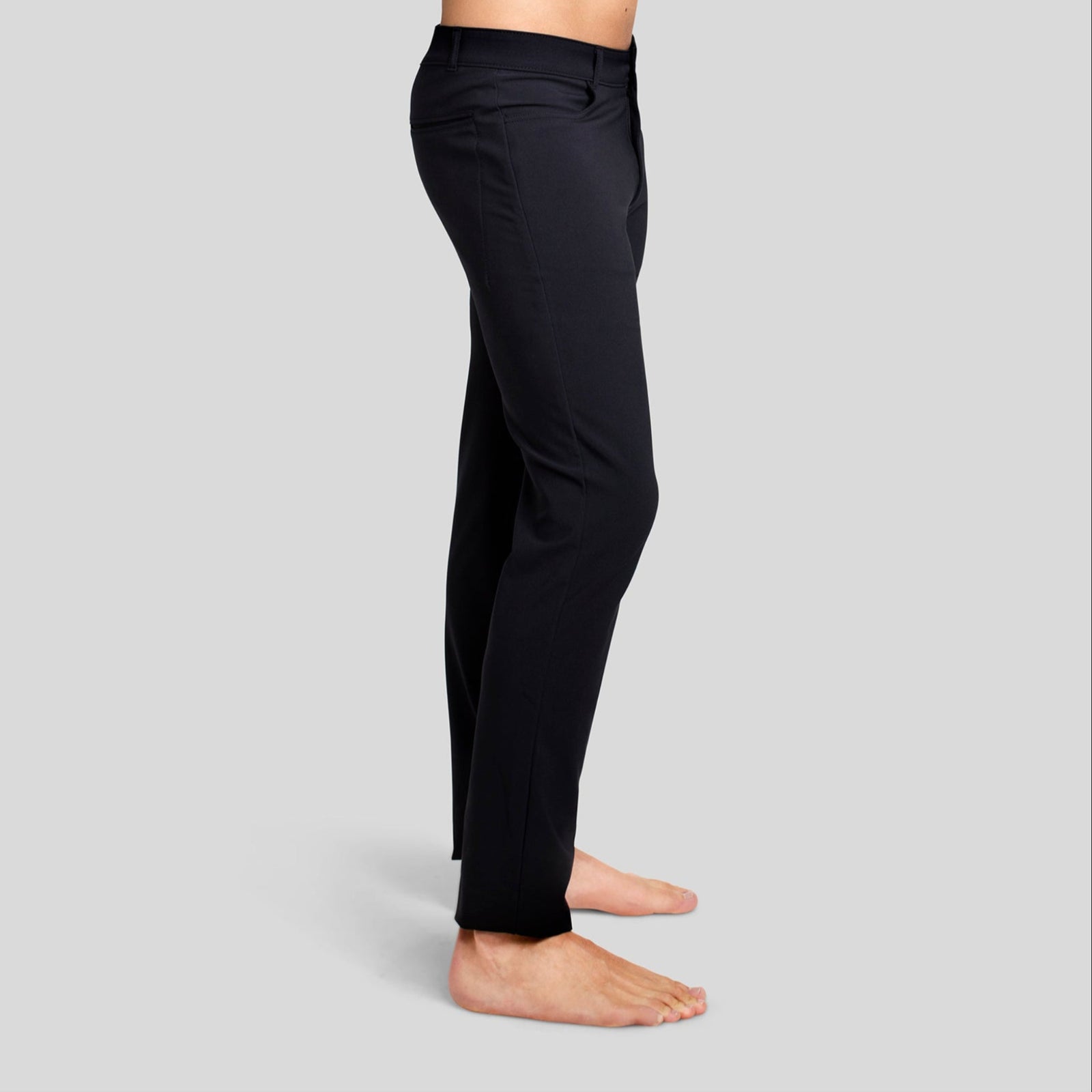 Side view of a man in The Pants by åäö in Tech Black, showcasing their sleek fit and timeless design.