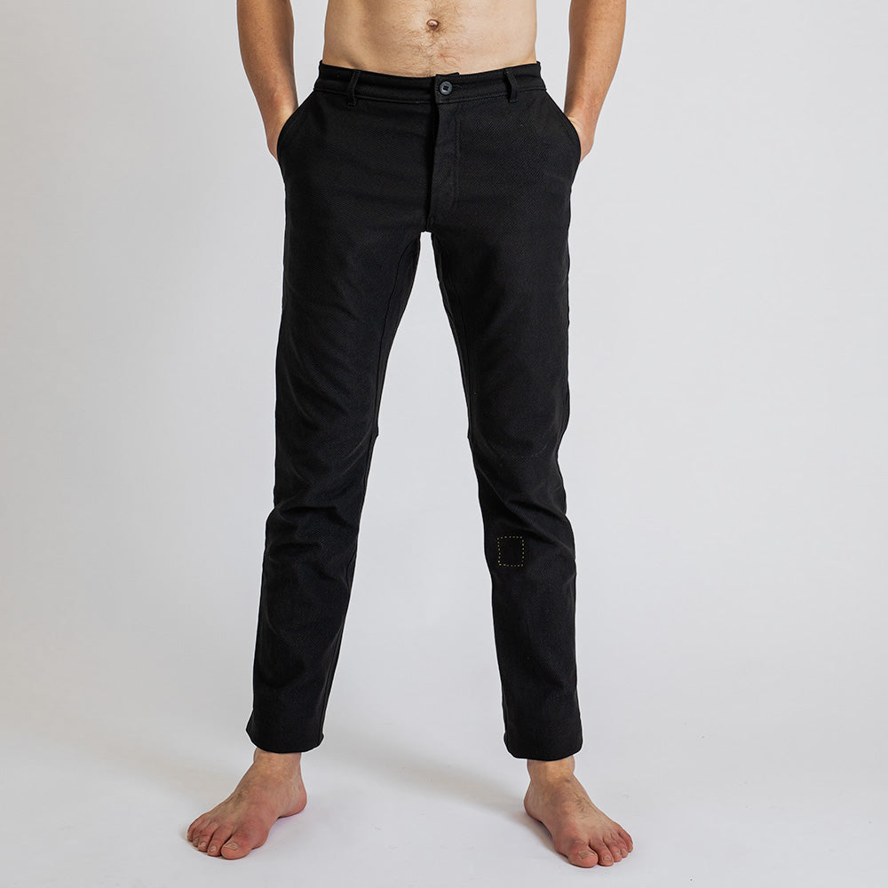 Front view of a man wearing åäö’s Forever Pants, highlighting the crafted texture of Dyneema fabric and the perfected fit. 