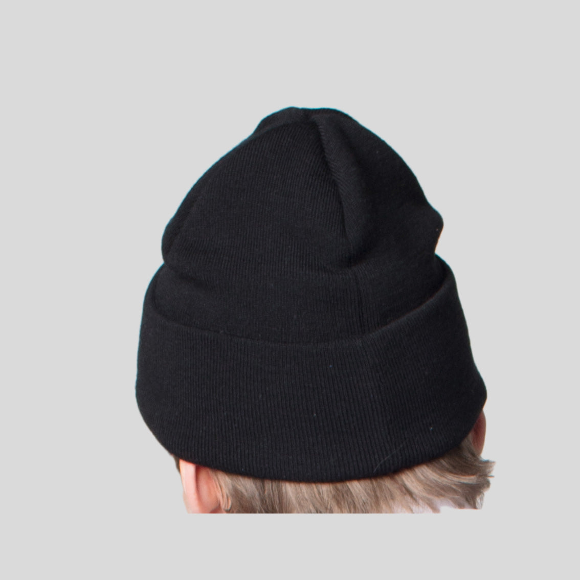 Rear-view of a man wearing åäö's Beanie, showing the meticulously crafted stitching in fine merino wool and its perfected fit.