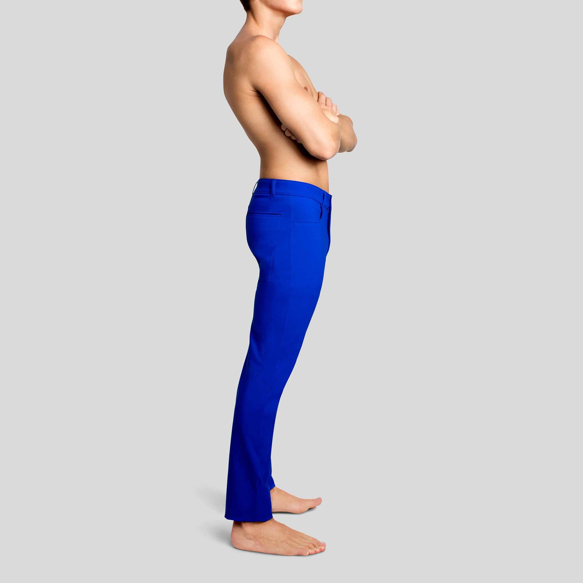 Side view of a man in The Pants by åäö in Brilliant Blue, showcasing their sleek design and tailored fit.