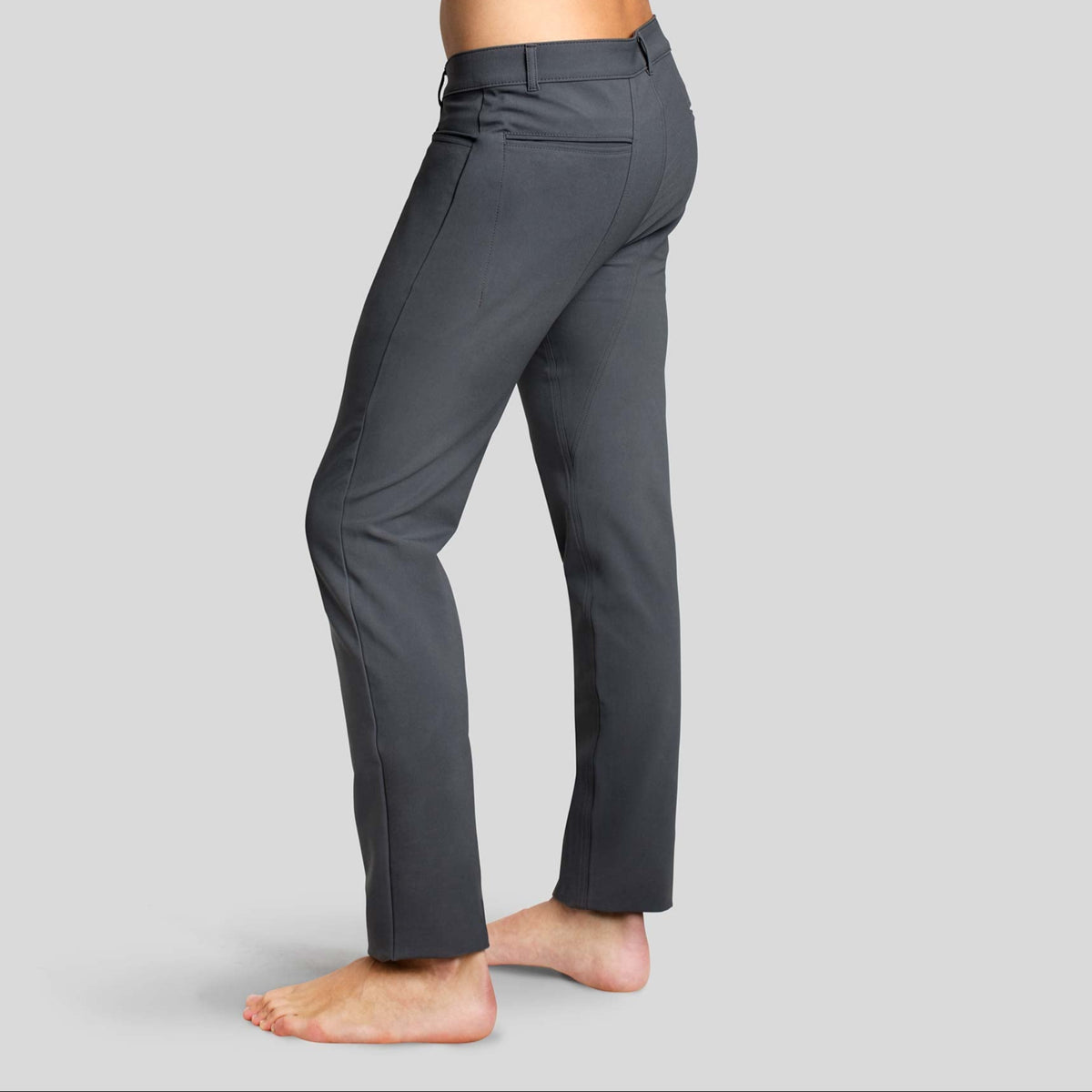 Side-back view of a man in The Pants by åäö in Rainy Day Grey, highlighting their timeless design and tailored fit.