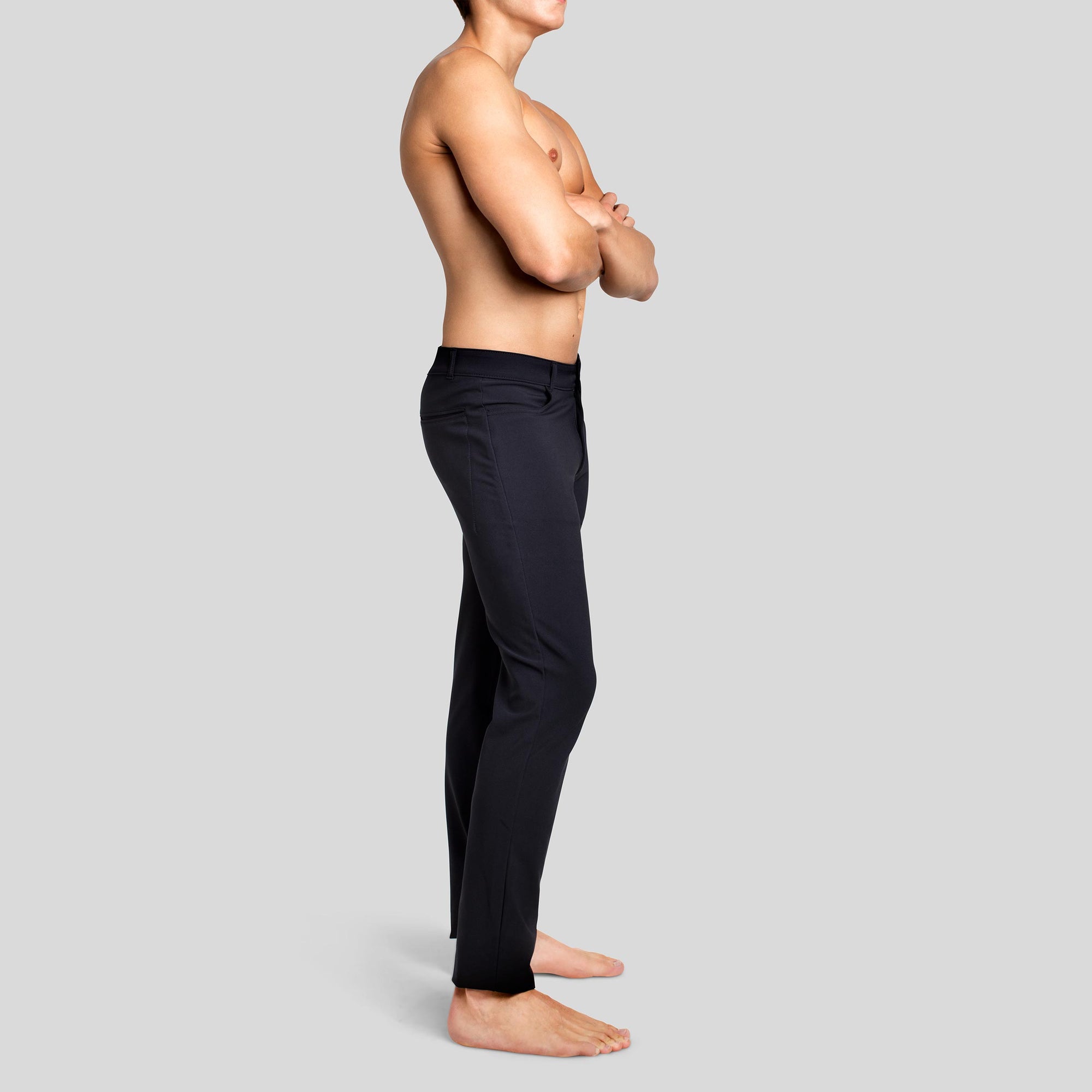 Side view of a man in The Pants by åäö in Tech Black, showcasing their sleek fit and timeless design.